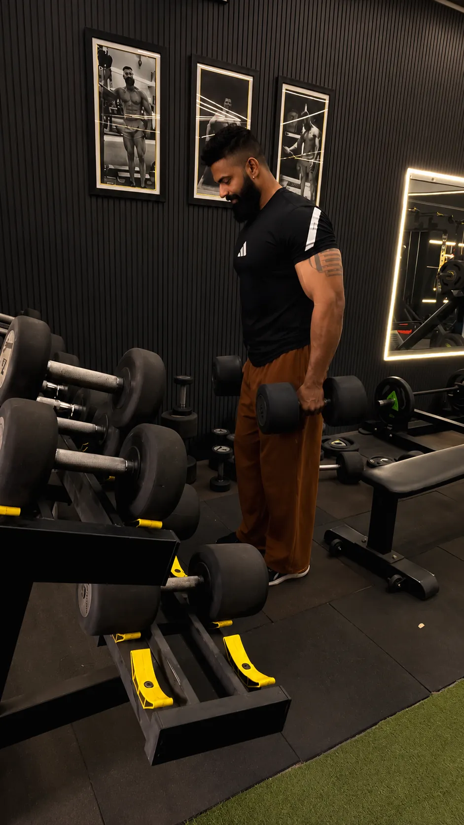Picking a dumbbell from the rack at POL Fitness